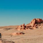 Gobi Desert - man in black jacket walking on brown sand during daytime