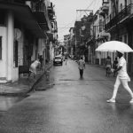 Havana Streets - man holding umbrella walking on gray road